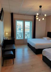 トゥルノン・シュル・ローヌにあるLe Châteauのベッド2台と窓が備わるホテルルームです。