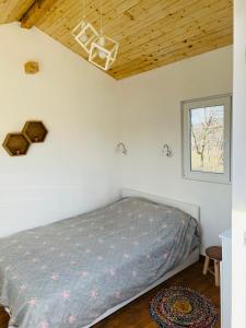 a bedroom with a bed and a wooden ceiling at Caravans 10 min to Tsonevo Lake & 35 min to Black Sea 