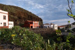 una colina con casas y edificios junto a una pared en Calle Montaña Aguarijo, en Mocanal