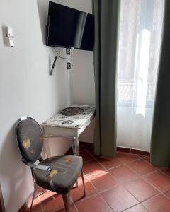 a desk with a chair and a television in a room at Dolce Vita Suite Alghero in Alghero