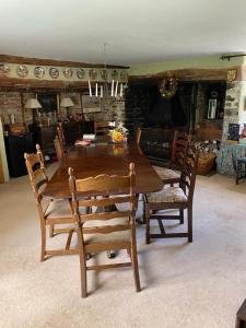 a dining room with a wooden table and chairs at Higher Biddacott Farm in Chittlehampton