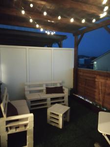 a porch with a bench and a table and lights at Hostal Stella Del Mare in Camariñas +19 photos