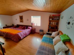 1 dormitorio con cama, sofá y reloj en El Zoela en Zamora