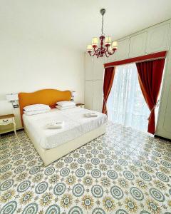 a bedroom with a large bed and a chandelier at Dolce Vita Suite Alghero in Alghero
