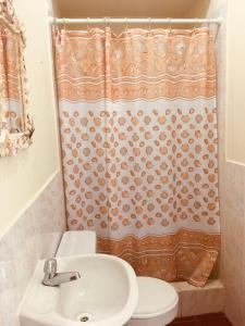 a bathroom with a sink and a shower curtain at Hotel La Punta in Montañita