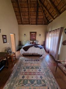 a bedroom with a bed and a rug at Thabanyani Mabalingwe in Bela-Bela
