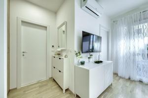 Habitación blanca con vestidor blanco y TV. en Apartment Alegria Zadar, en Zadar 22 fotos más