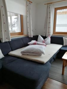 a couch with pillows on it in a room at Ferienwohnung Kaufbeurerhausblick in Hinterhornbach