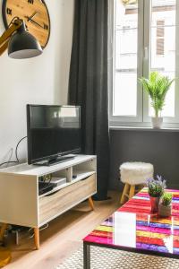 un soggiorno con TV su un tavolo di Parking - Le Wild Forest - Centre Historique a Phalsbourg