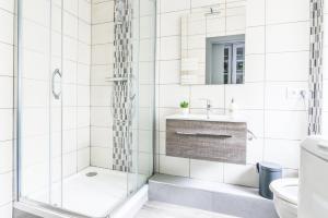 un bagno bianco con doccia e lavandino di Parking - Le Wild Forest - Centre Historique a Phalsbourg Altre 23 foto