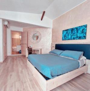 a bedroom with a blue bed and a bathroom at Locanda Sapori in Sanremo