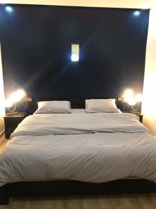 a bedroom with a large bed with two lights on it at Pedro Appartement in Essaouira