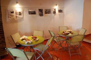 ein Esszimmer mit zwei Tischen und Stühlen und Bildern an der Wand in der Unterkunft Solar Dos Viscondes - Turismo De Habitacao in Ferreira do Alentejo + 41 Fotos