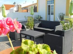 d'une terrasse avec des canapés, des chaises et une table. dans l'établissement Solar Dos Viscondes - Turismo De Habitacao, à Ferreira do Alentejo