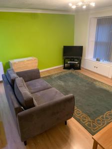 a living room with a couch and a television at Lovely 2-bedroom apartment in Scottish Borders in Earlston