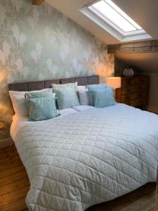 a bedroom with a large white bed with blue pillows at No. 16 Lytham in Lytham St Annes