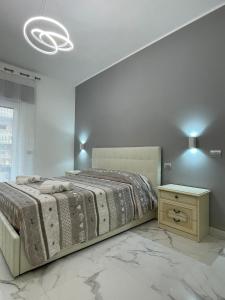 a bedroom with a large bed and a night stand at Mare di Roma in Lido di Ostia