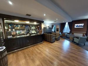 um quarto com um bar e algumas cadeiras em The Tarbet Hotel em Tarbet