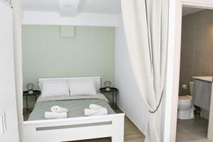 Beach Holiday Homes في مدينة ريثيمنو: غرفة نوم صغيرة عليها سرير وفوط