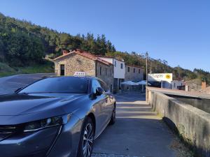 un coche azul estacionado al lado de una carretera en Albergue O Logoso, en Campelo