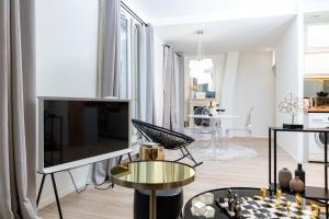 un soggiorno con grande TV e tavolo di Appartement Design&Nouveau, ParisExpo Pte-de-Versaille, Parking&Netflix a Issy-les-Moulineaux Altre 28 foto