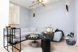 uma sala de estar com um sofá branco e uma mesa em Appartement Design&Nouveau, ParisExpo Pte-de-Versaille, Parking&Netflix em Issy-les-Moulineaux