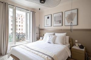 una camera da letto con un letto grande e una finestra di Appartement Design&Nouveau, ParisExpo Pte-de-Versaille, Parking&Netflix a Issy-les-Moulineaux