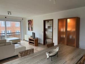 salon z kanapą i stołem w obiekcie Ruim zonnig appartement op 50m van strand w Ostendzie