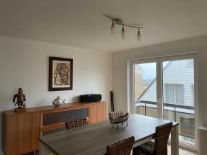 ein Esszimmer mit einem Tisch, Stühlen und einem Fenster in der Unterkunft Ruim zonnig appartement op 50m van strand in Ostende