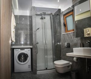 bagno con lavatrice e lavandino di Seaside Luxury Apartments Kremasti a Kremasti