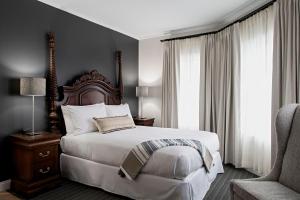 a bedroom with a large bed and a chair at The Federal in Brunswick