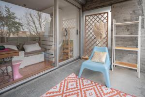 Una habitación con una silla azul y un dormitorio en WAIKIKI-Garage-Terrasse-Fibre-Ensoleillé-Calme-à 10min du centre ville-Clermont-Ferrand, en Chamalières