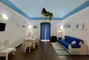 a living room with a blue couch and a table at Porto Salvo Apartments - by Vacation Service in Cefalù
