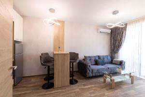 a living room with a blue couch and a table at Helena Holiday B in Saints Constantine and Helena