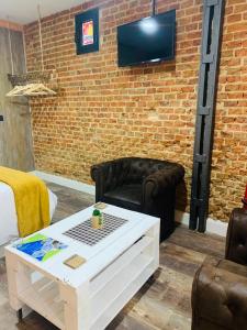 a living room with a couch and a tv on a brick wall at T-Homes Salamanca in Madrid