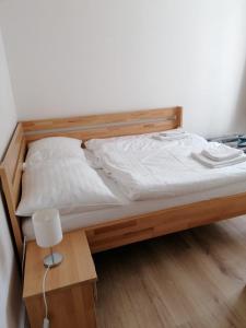 a bed with a wooden bed frame and a lamp at Apartmán 68 Horní Lipová in Lipova Lazne