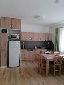 cocina con mesa y nevera blanca en Apartmán 68 Horní Lipová, en Lipová-lázně