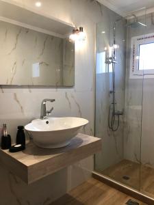 a bathroom with a sink and a shower at New delux studio with wooden floor in Chania