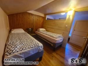 a bedroom with two beds and a window at KAN AN DOUR in Laniscat