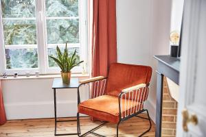 a chair and a table in a room with a window at Demeure de Manneville - SPA - 1Km des plages de Cabourg in Dives-sur-Mer