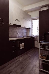 a kitchen with white cabinets and a sink at L’Archè Lodovico il Moro – House on the Navigli River in Milan
