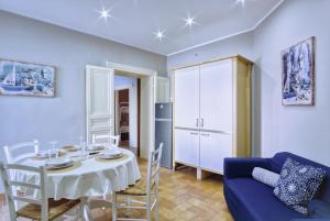 a living room with a table and a blue couch at Porto Salvo Apartments - by Vacation Service in Cefalù