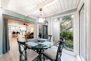 a dining room with a glass table and chairs at 1217 Lagoon Villas in Fernandina Beach