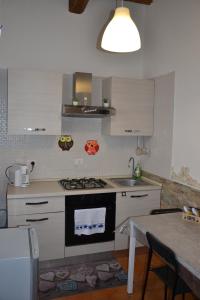 a kitchen with a stove and a sink and a table at Al centro del porto in Civitavecchia