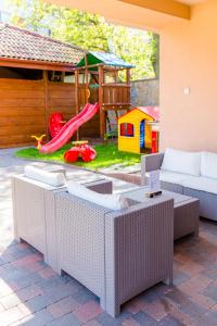 patio con parque infantil con sofá y tobogán en B&B Penzión Magura en Bardejov