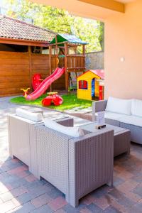 eine Terrasse mit einem Spielplatz mit einem Sofa und einer Rutsche in der Unterkunft B&B Penzión Magura in Bardejov