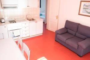 a living room with a couch and a kitchen at Orquideas in Cala Galdana