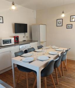 a kitchen with a table and chairs and a kitchen with a table and chairsktop at Les Belles Terrasses Dieppe ,3 appartements , LE VEGETAL de 1 à 8 personnes , LE TROPICAL de 1 à 6 personnes , LE FLORAL avec TERRASSE de 1 à 3 personnes , quartier calme au stationnement gratuit à coté de l'avenue verte in Dieppe