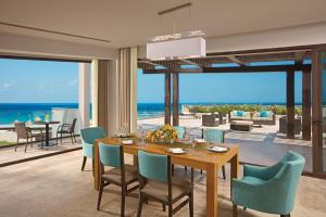 a dining room with a table and chairs and the ocean at Dreams Playa Mujeres Golf & Spa Resort - All Inclusive in Cancún