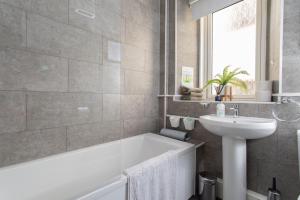 a bathroom with a white tub and a sink at The Old Post House in Kyle of Lochalsh +38 photos